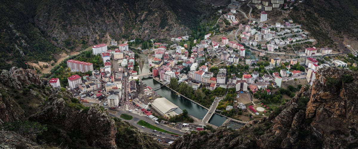 A mountainous town with buildings clustered along a river.