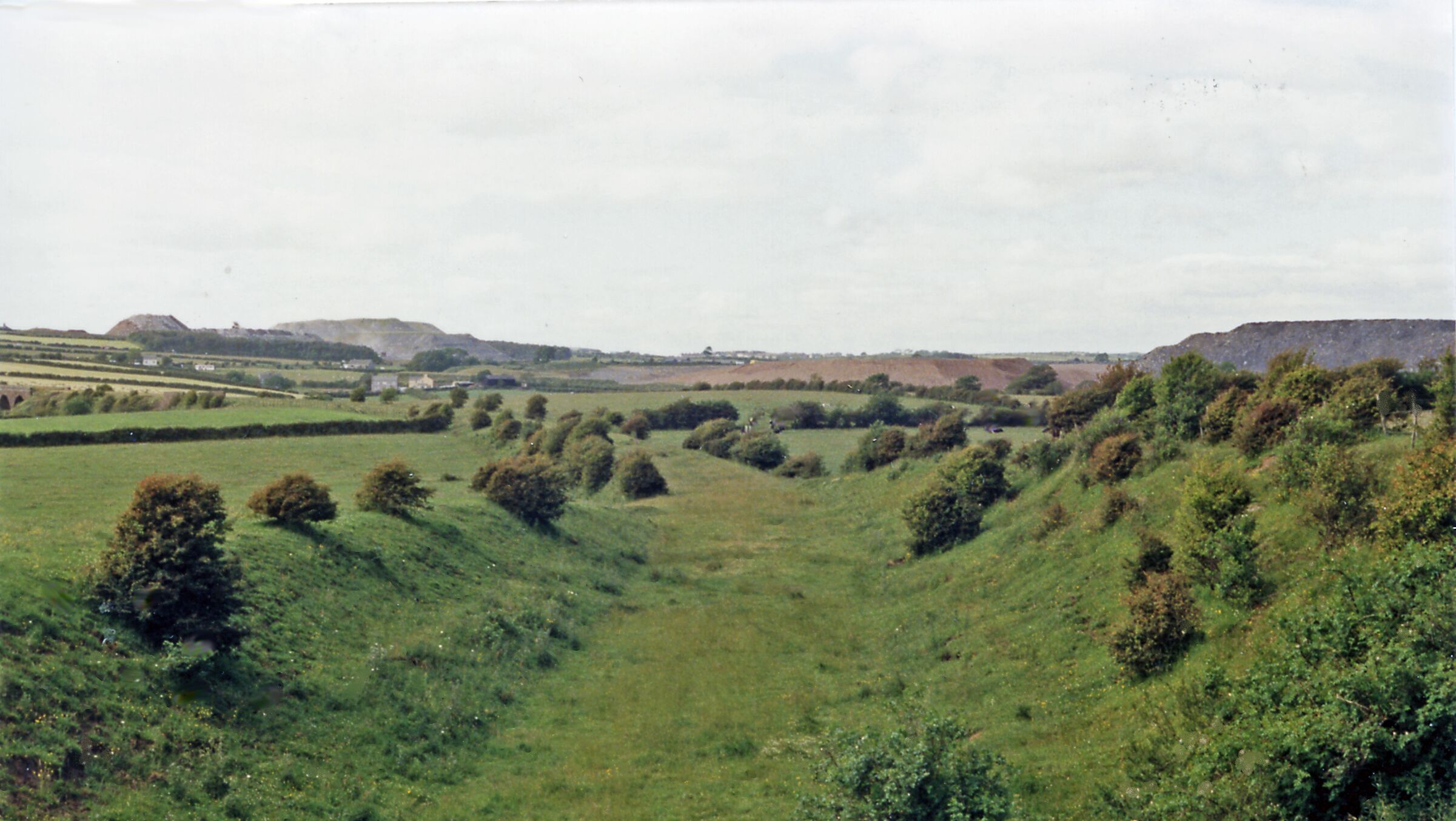 Rolling hills, a river, and distant buildings.