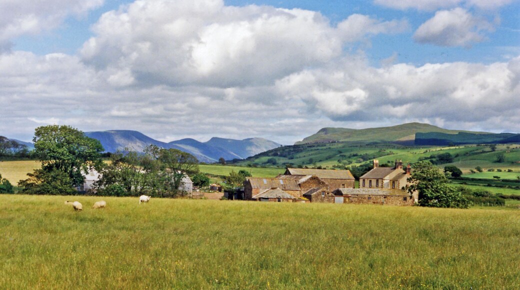 Eastward towards Ennerdale from near Cleator Moor. A fine panorama of the mountains around Ennerdale, seen from just off the B5294 Cleator - Frizington road at Threapthwaite. To the left is Murton Fell (1,461 ft.), Blake Fell (1,626 ft.), then Great Borne (2,018 ft.) and Starling Dodd (2,077 ft.) shining in sunlight NE of Ennerdale Water, while rather nearer on the right is Grike (1,556 ft.) joined to the Ennerdale Fells which line the south side of Ennerdale Water.