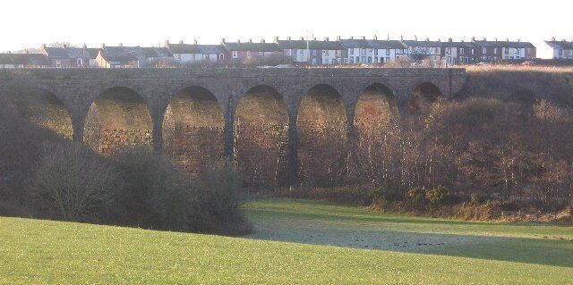 Keekle Viaduct. The view over the nicely kept farmland on this eastern side is in complete contrast to the undergrowth on the other side. The row of houses behind is Keekle.
