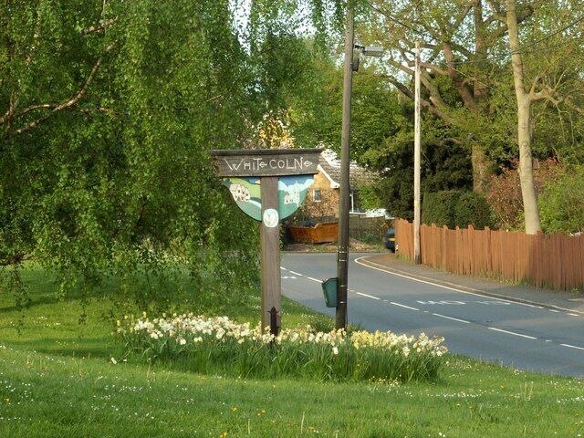 White Colne's village sign The main road is the A1124.