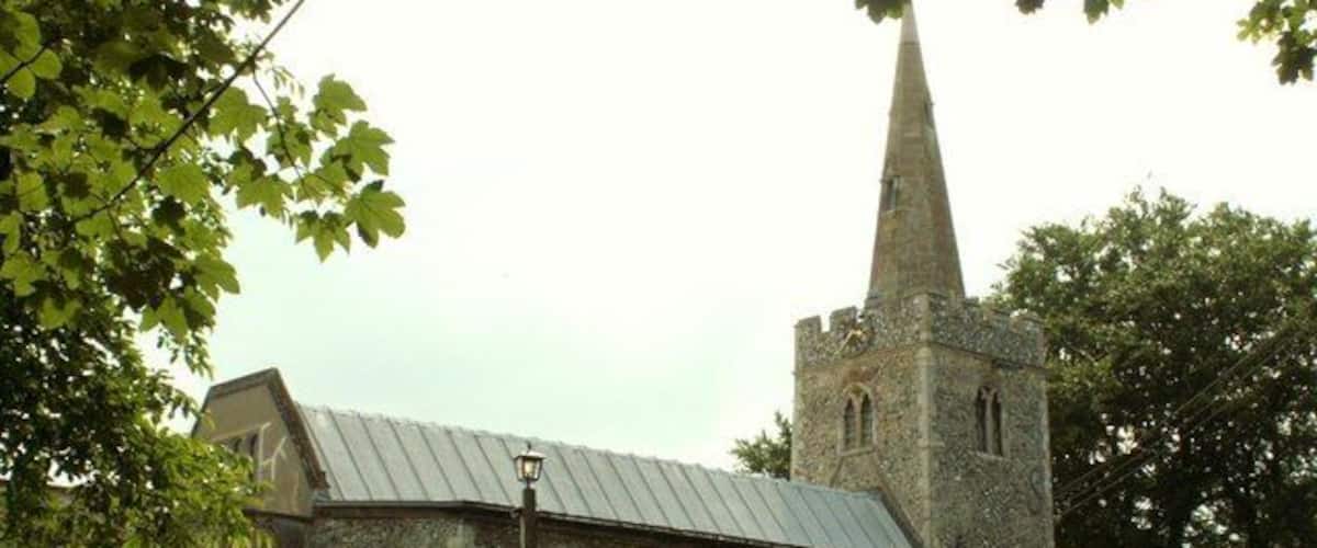 A church with a tall spire and a stone building.