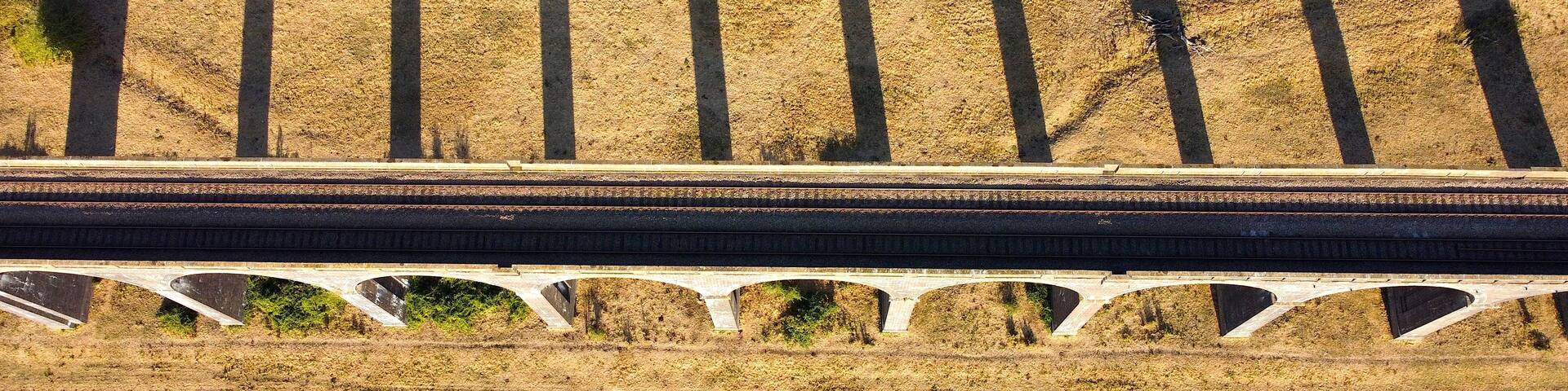 A railway bridge with multiple arches and a railway track.