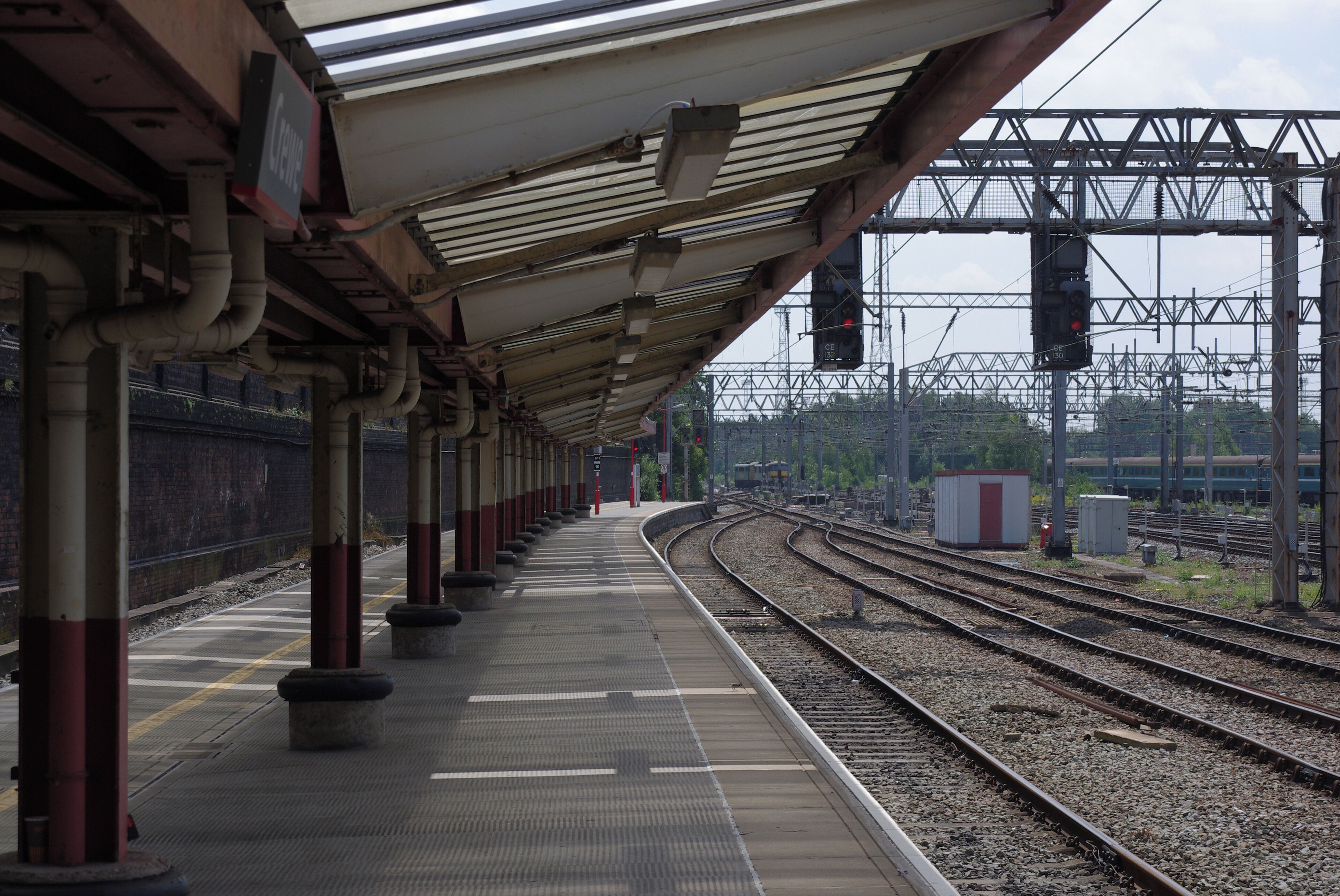 Looking south along the long western platform at Crewe railway station. In the background are Freightliner electric locomotives 86604 and 90048.