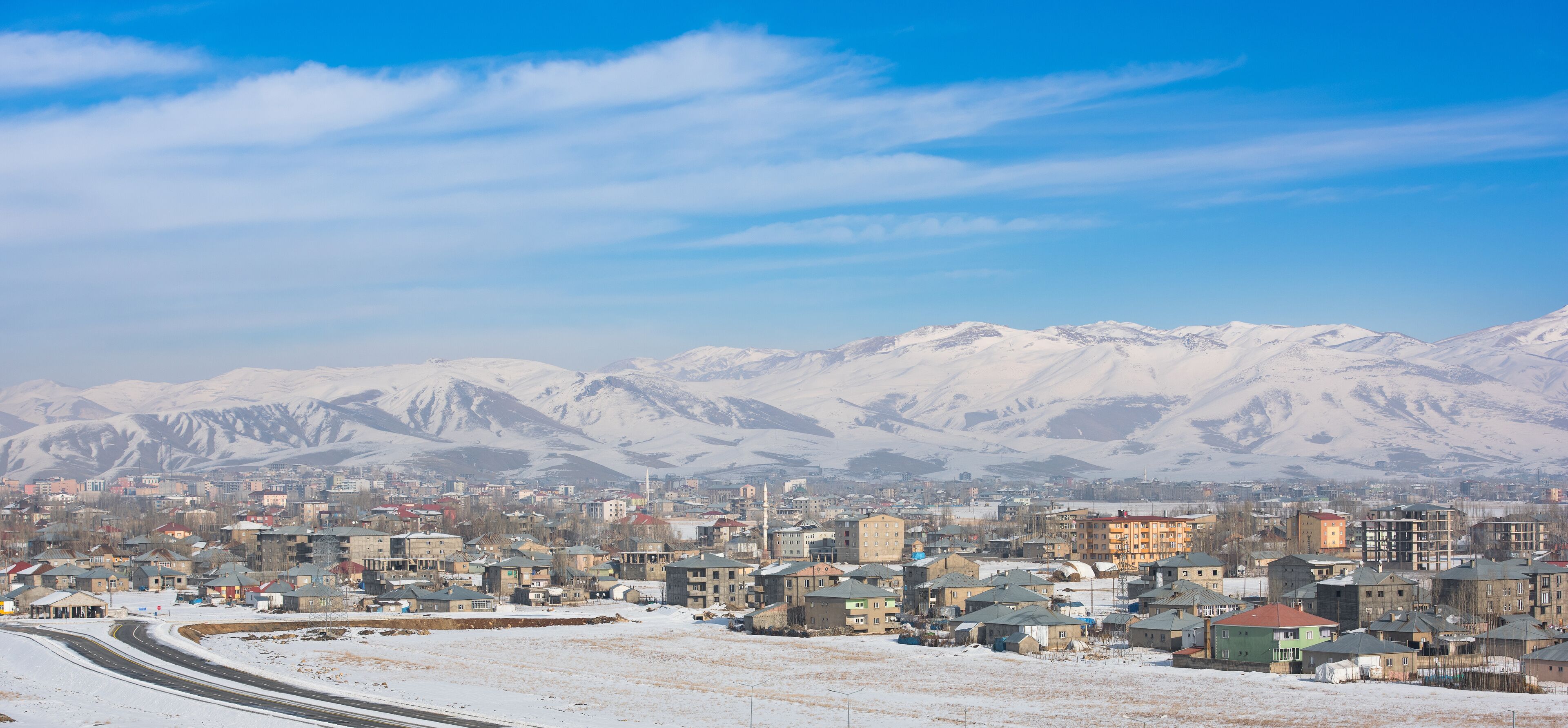 A snowy cityscape with mountains in the background.