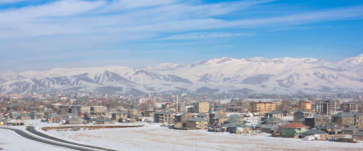 A snowy cityscape with mountains in the background.