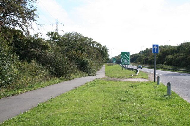 A pathway alongside a road with a directional sign and a blue arrow sign.