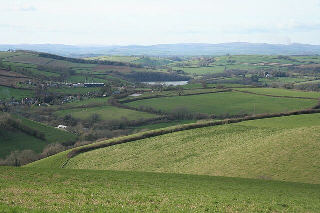 Dittisham: towards East Cornworthy In the distance, beyond the square, Bow Creek is hidden to the left of a bend in the river Dart. Dartmoor provides the horizon and a plume of smoke to the right, just distinguishable from cloud, indicates that swayling is in progress