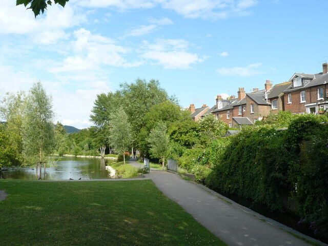 Zona residencial con un canal, césped verde y casas.