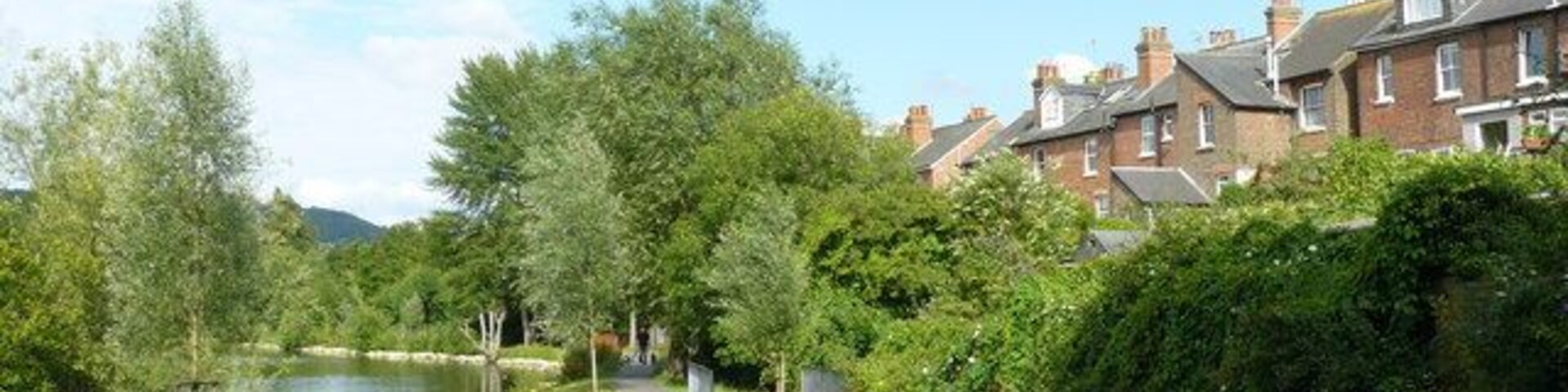 Zona residencial con un canal, césped verde y casas.