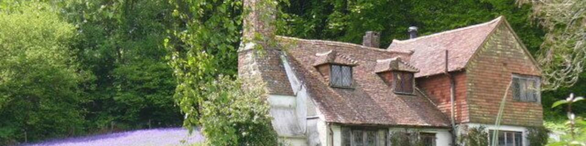 Wealden Idyll Vernacular tile-hung cottage in a beautiful Wealden setting. The blue tinge in the background is a mass of bluebells.