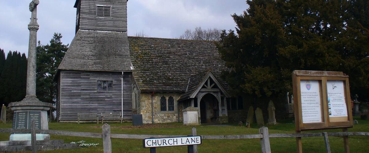 A church with a tall steeple and a sign reading "Church Lane".
