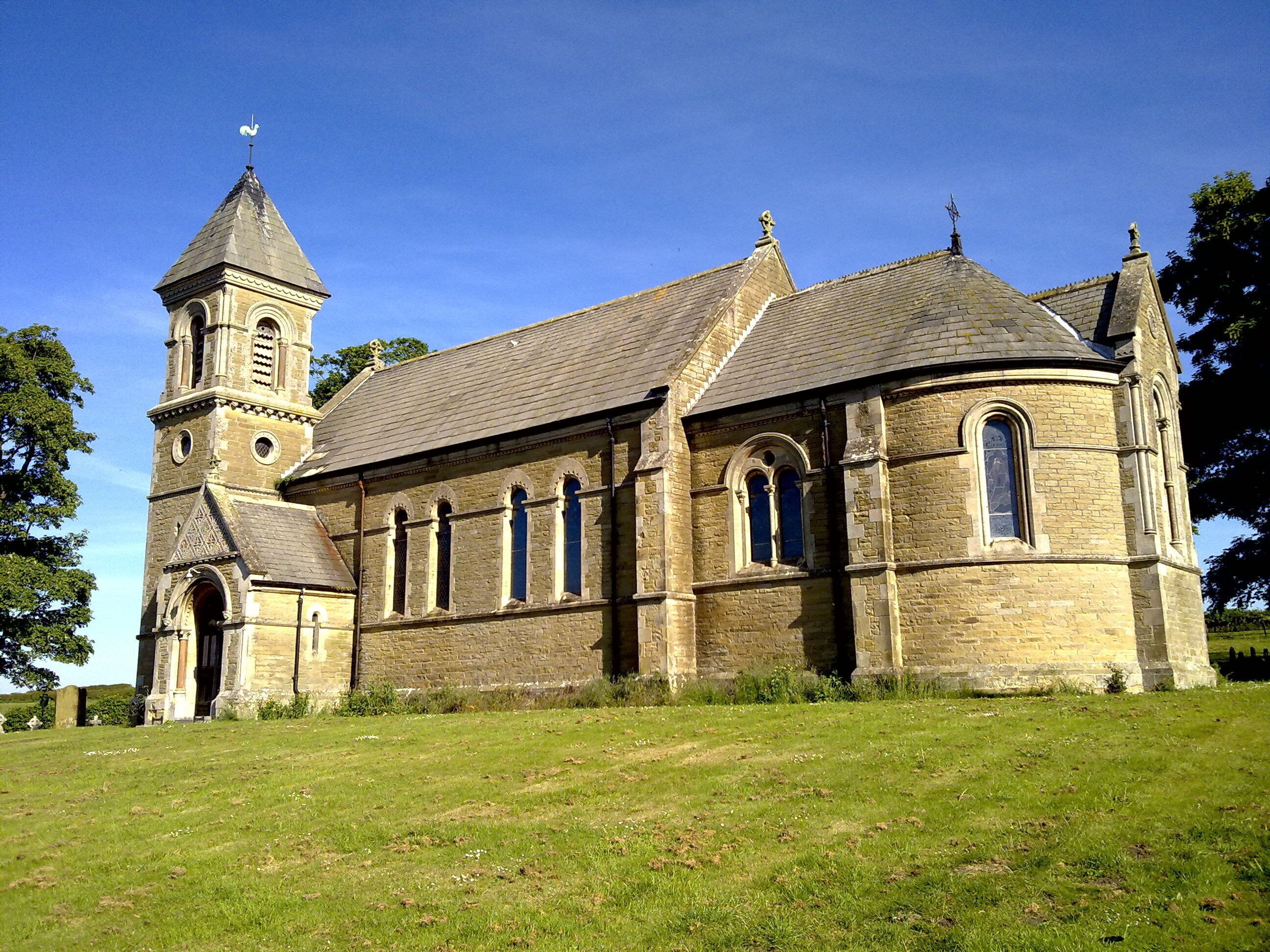 A historic church with a prominent tower and arched windows.