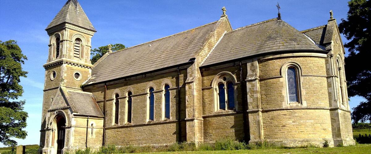 A historic church with a prominent tower and arched windows.