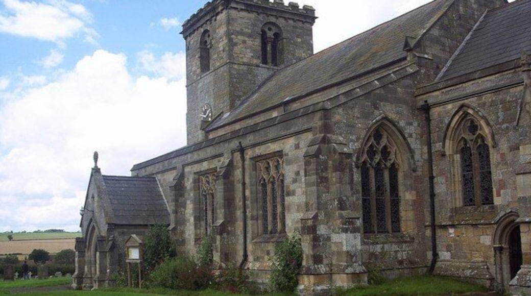All Saints Church, Rudston, East Riding of Yorkshire, England. All Saints Church is nearly as famous as the Monolith attracting hundreds of visitors each year. It has a 12th Century chancel arch and a Norman tower.