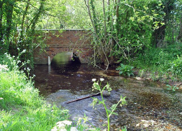 The bridge over Eastburn Beck, Kirkburn, East Riding of Yorkshire, England. The water comes from springs a little further west, and flows past the photographer on its way to join the river Hull. The water is beautifully clean.