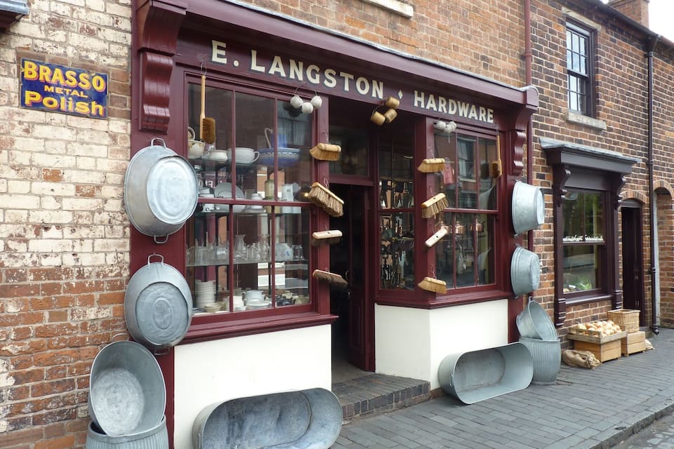 A hardware store named E. Langston Hardware with metal buckets and a brass polish sign on the wall.