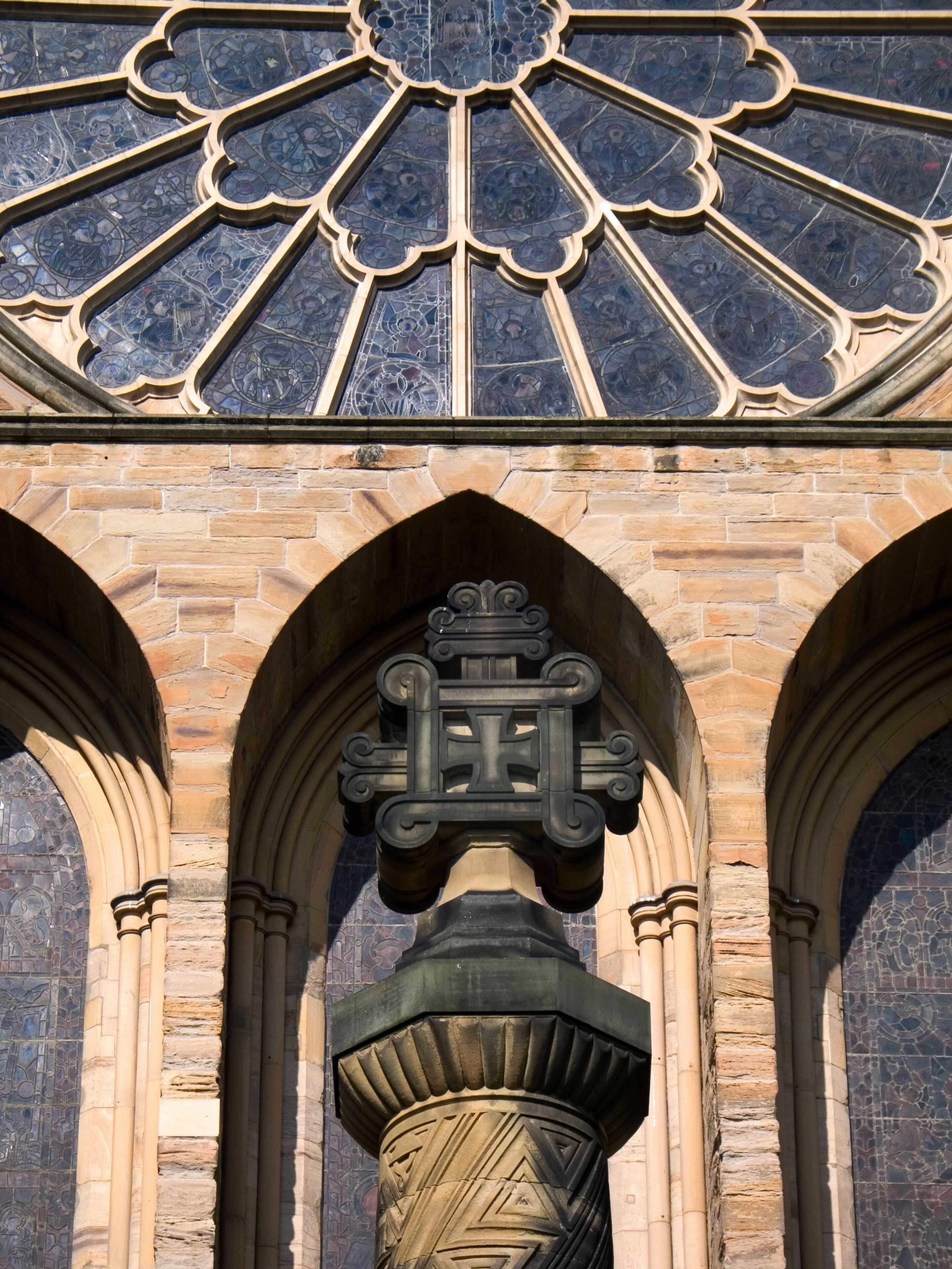A stone archway with a decorative keystone and a stained glass window above.