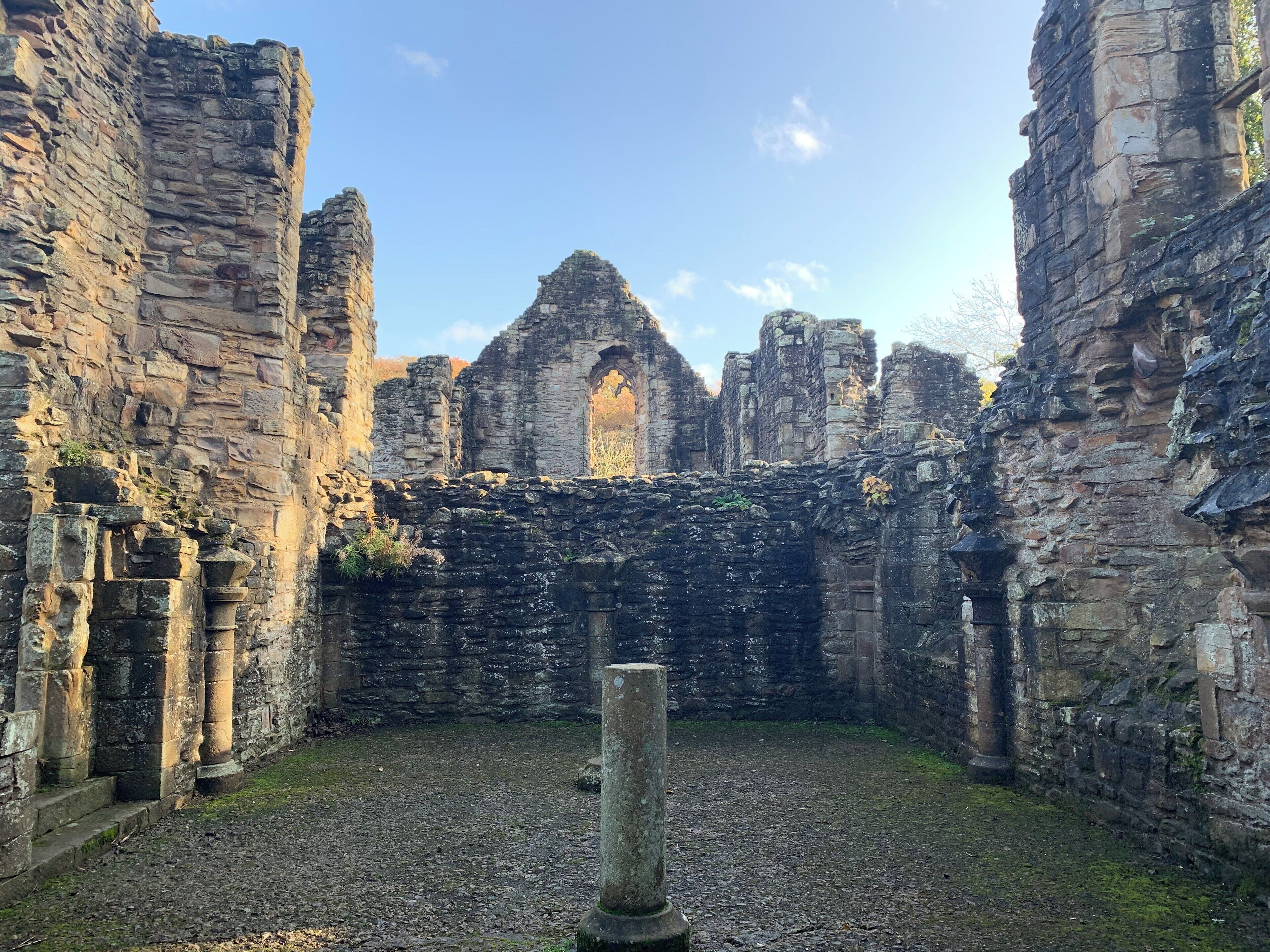 An ancient stone structure with ruins and a clear sky.