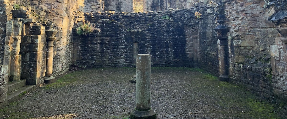 An ancient stone structure with ruins and a clear sky.