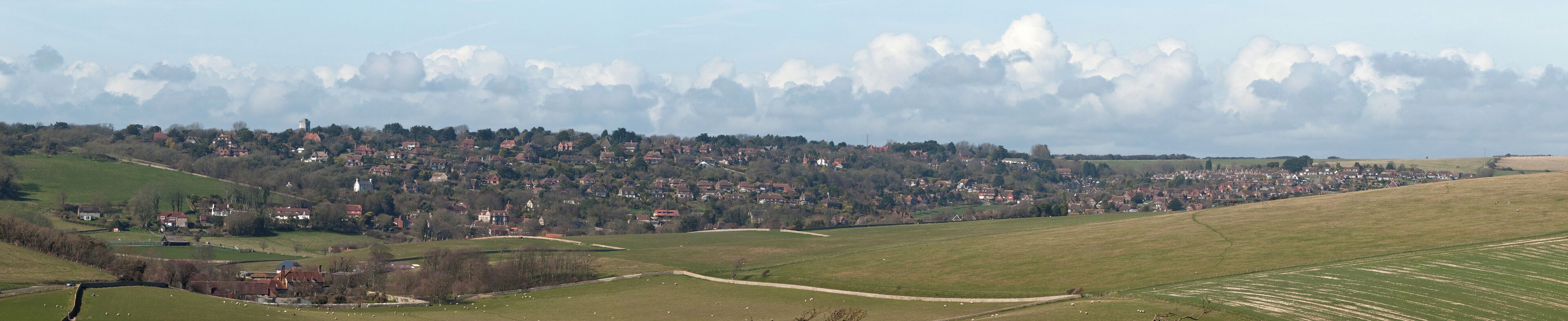 The villages of East Dean (lower valley) and Friston (upper valley) as viewed from along the South Downs Way near Birling Gap in East Sussex, England.