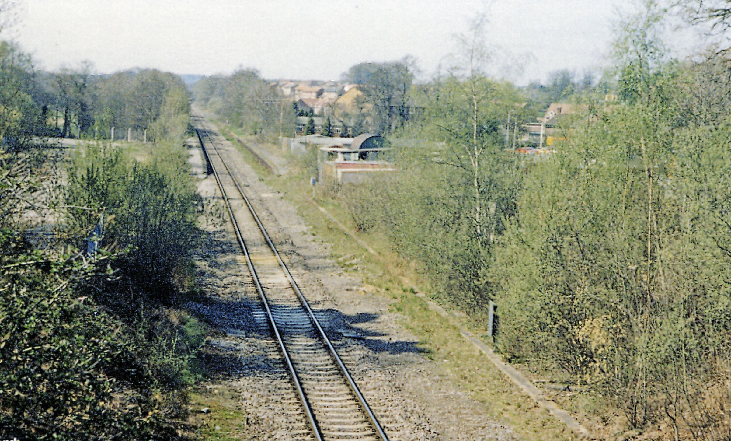 Chandler's Ford station (remains), 1984. View NW, towards Romsey and Salisbury: ex-LSWR Eastleigh - Romsey - Salisbury/Andover line. In the past it had been quite a busy line, especially for freight, but by 1984 is reduced to a single-line running only through to Salisbury, Romsey - Andover Junction having closed from 7/9/64. Chandlers Ford station was closed from 5/5/69, but as the area became increasingly populated, a new station was built, opening on 19/10/03, and a local service was re-introduced from Romsey - Eastleigh - Southampton