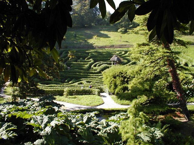 A lush garden with neatly trimmed hedges and a winding path.