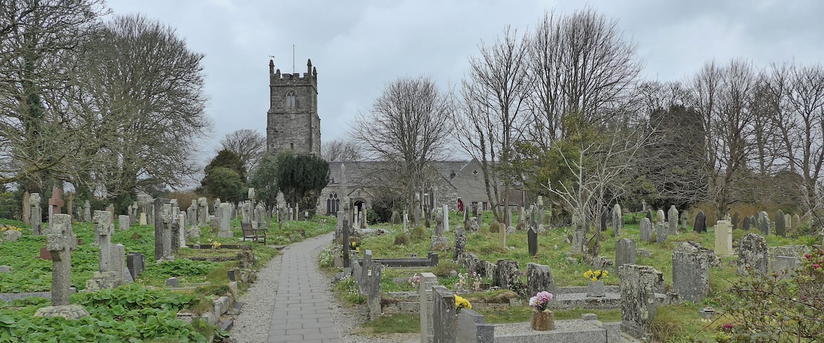 A cemetery with a pathway leading to a church tower.