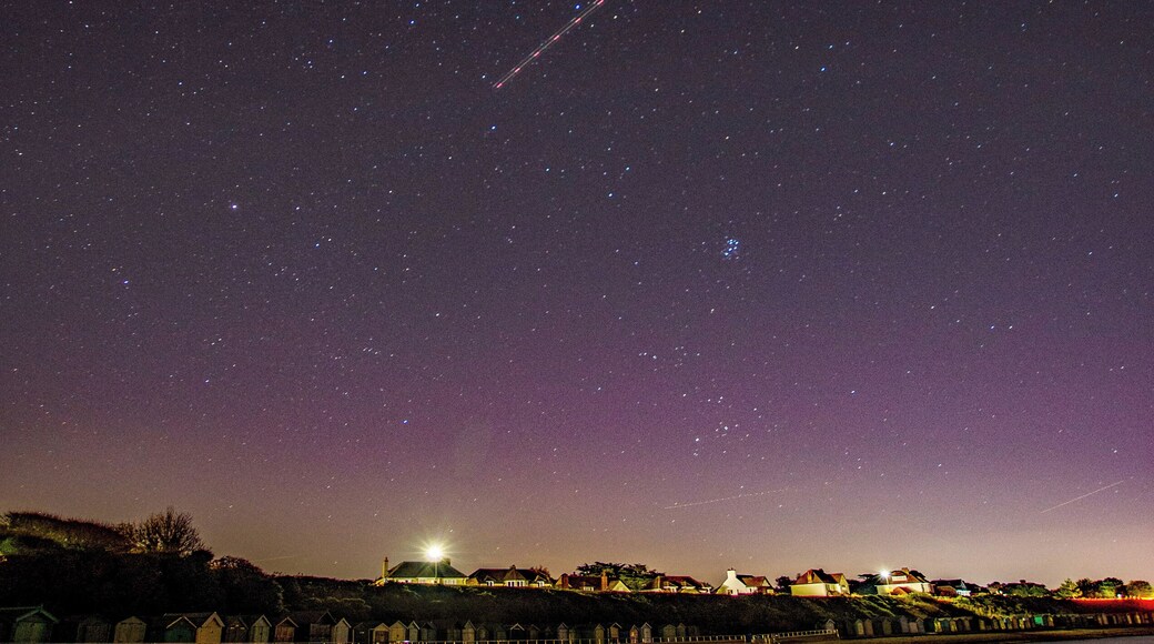 View of beach huts under a starry sky.