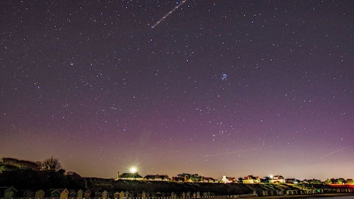 View of beach huts under a starry sky.