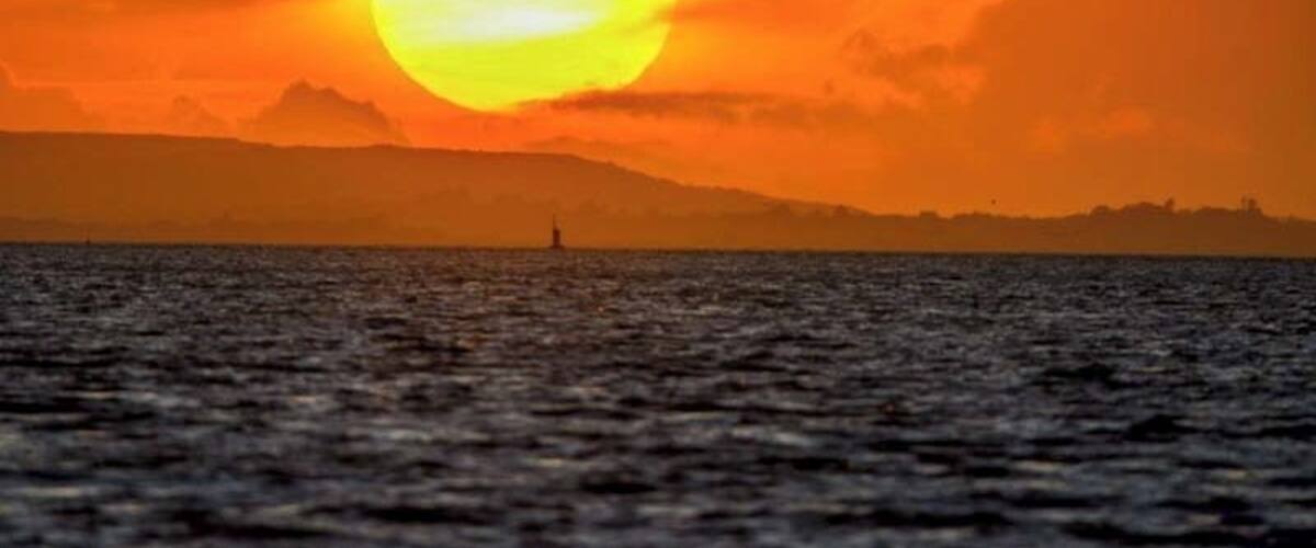 Sunset over the Isle of Wight as viewed from across the Solent at Hillhead harbour.