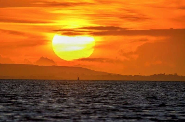 Sunset over the Isle of Wight as viewed from across the Solent at Hillhead harbour.