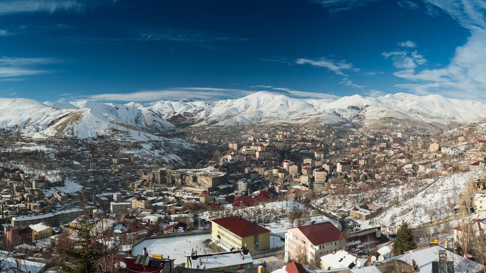 A snow-covered town with mountains in the background.