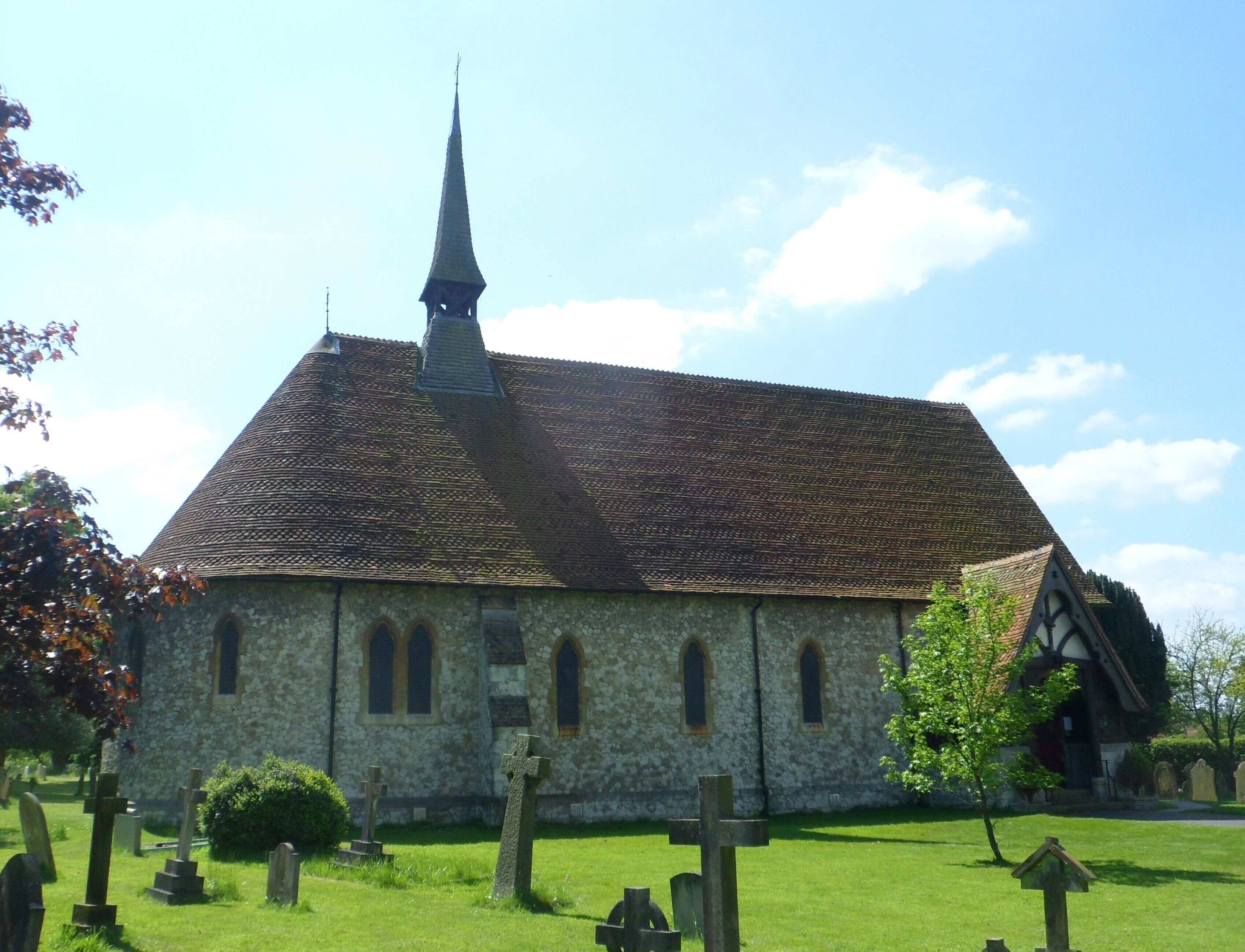 A church with a tall steeple and a stone facade.