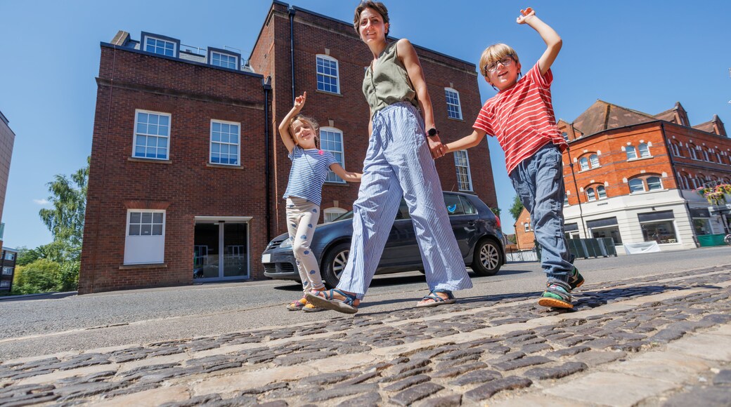 Happy stroll on bright day of family, in downtown, Farnham, UK