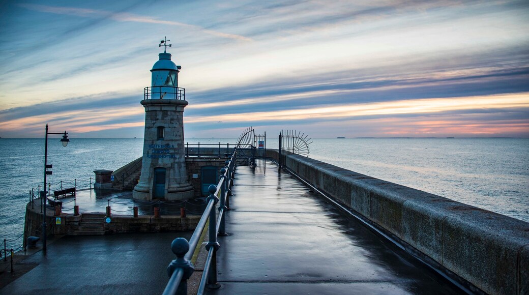 Folkestone's Harbour Arm and Lighthouse at dawn.