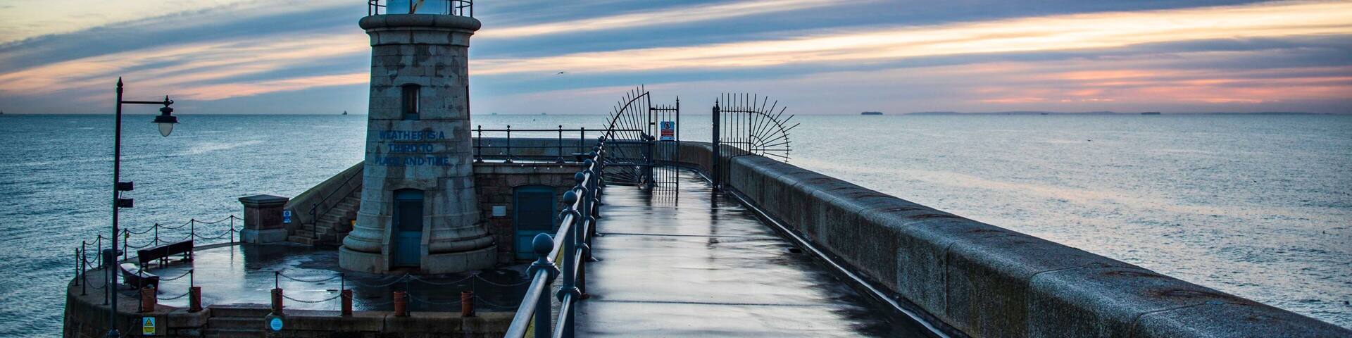 Folkestone's Harbour Arm and Lighthouse at dawn.