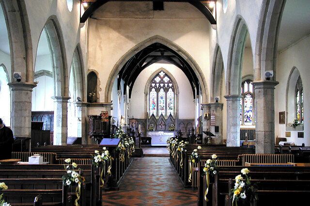 An interior of a church with arched ceilings, pews, and stained glass windows.