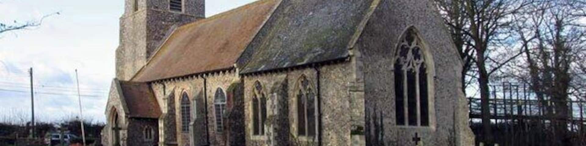 Uma igreja histórica com uma torre e janelas em arco.
