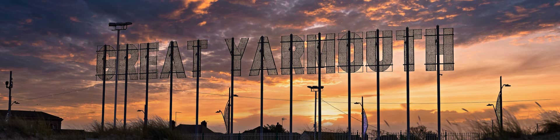 Colourful dramatic sunset landscape with Great Yarmouth sign.