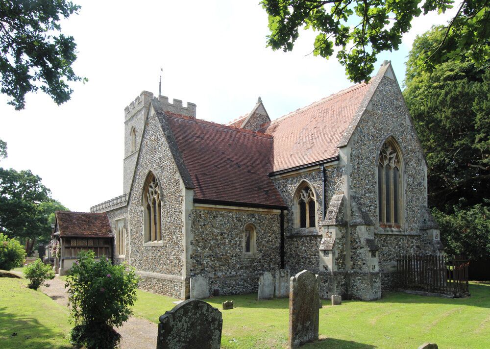 A stone church with a red-tiled roof and Gothic windows.