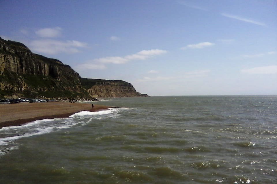 A beach with cliffs and the ocean.