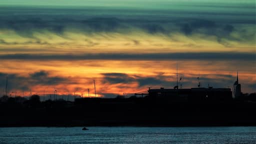 On the western tip of Hayling Island you can see the sun set behind Portsmouth's Spinnaker Tower and the small harbour on the other side of the sea channel. Large car park with walking access to the large sand beach on the corner. #perspective