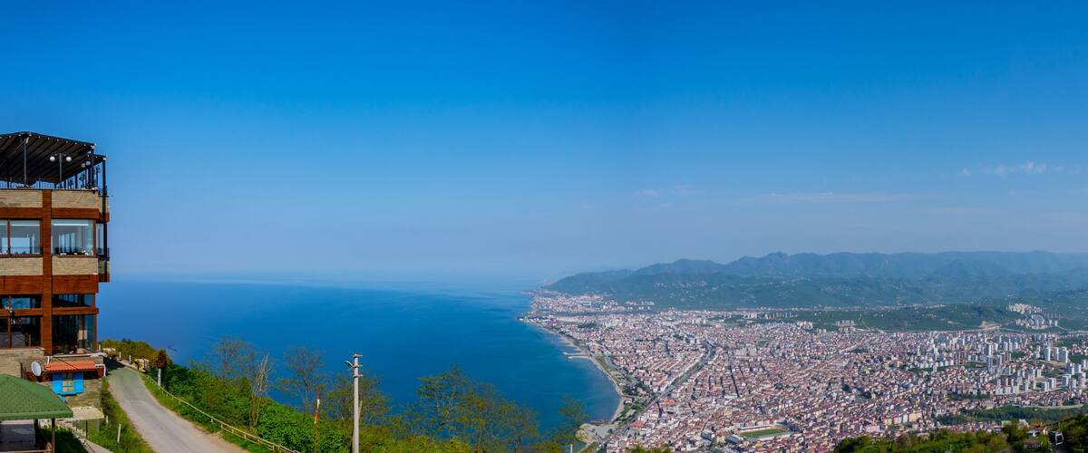A coastal city with a view of the sea and mountains in the background.