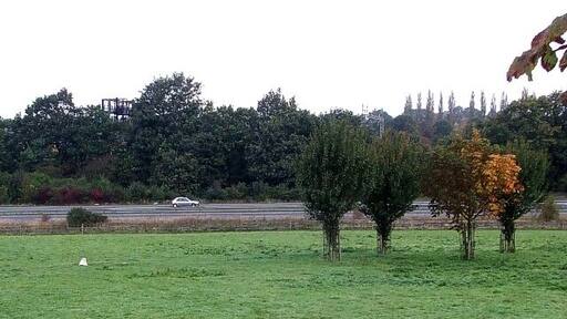Snook's Grave from London Road. The little white stone marks the supposed site of the grave of Robert Snooks, the last highwayman to be executed in England at the scene of his crime. His real name was James Blackman Snook, the "Robert" probably being a corruption of "Robber" and the final S from the possessive case. Closer views can be seen 999762 & 999781 where you will find more information about him & his crime.