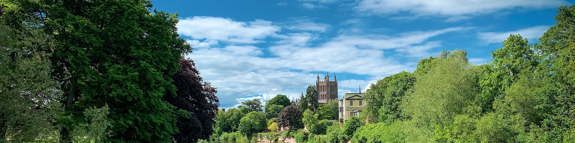 Looking across the River Wye to Hereford Cathedral on a beautiful spring day in Hereford, Herefordshire, UK. A mobile phone photo with some phone or tablet post processing.