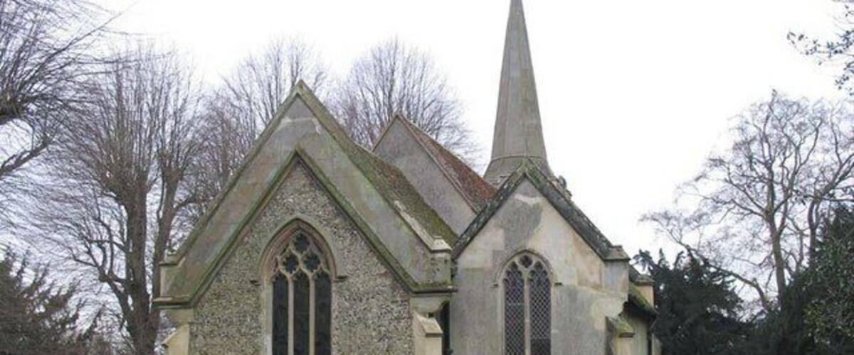 A small stone church with a pointed steeple and arched windows.