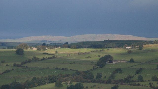 Winshield Crags The line of Hadrian's Wall on Windshields Crags is sunlit through a narrow break in the dark clouds.