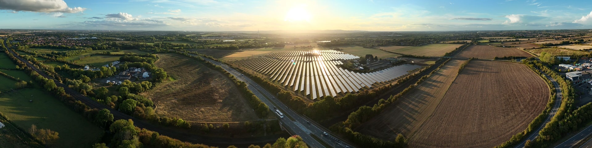 Wide angle aerial drone view of Solar power plant, photovoltaic panels and rural landscape, energy generation electricity at sunset summer Leicestershire England UK