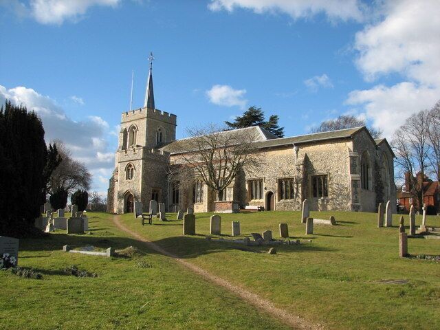 A church with a tall steeple and a graveyard in front.